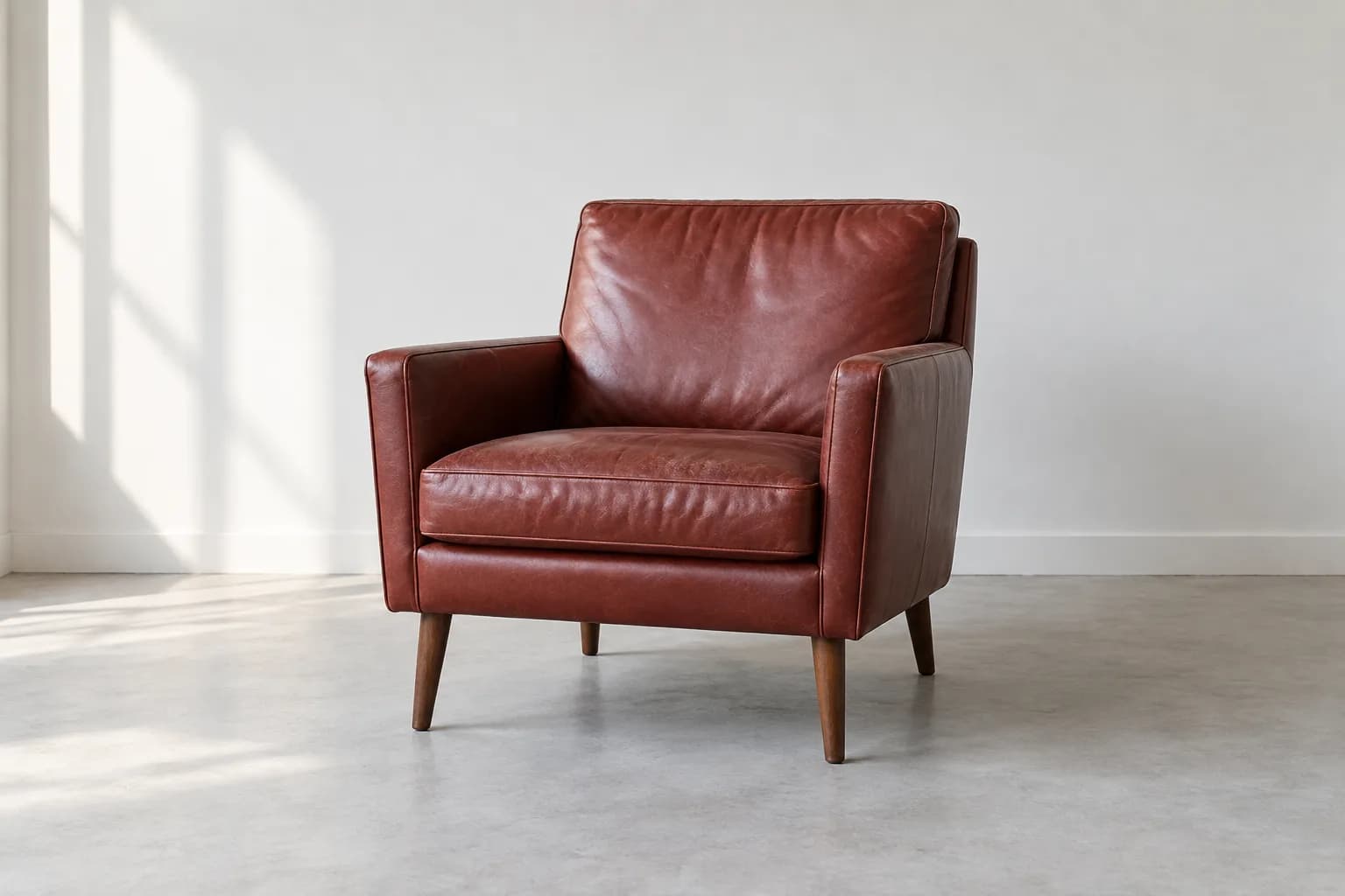 Red leather armchair with natural-looking grain and soft creases in a bright room
